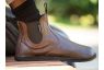 barefoot chelsea boot worn by a man on a park bench
