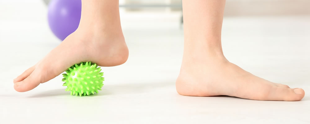 Treating Foot Problems Naturally a foot massaging against a spiky ball