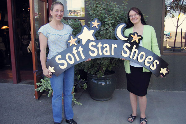 Tricia and Larkin hold the original Softstar sign in front of the old workshop in 2005.